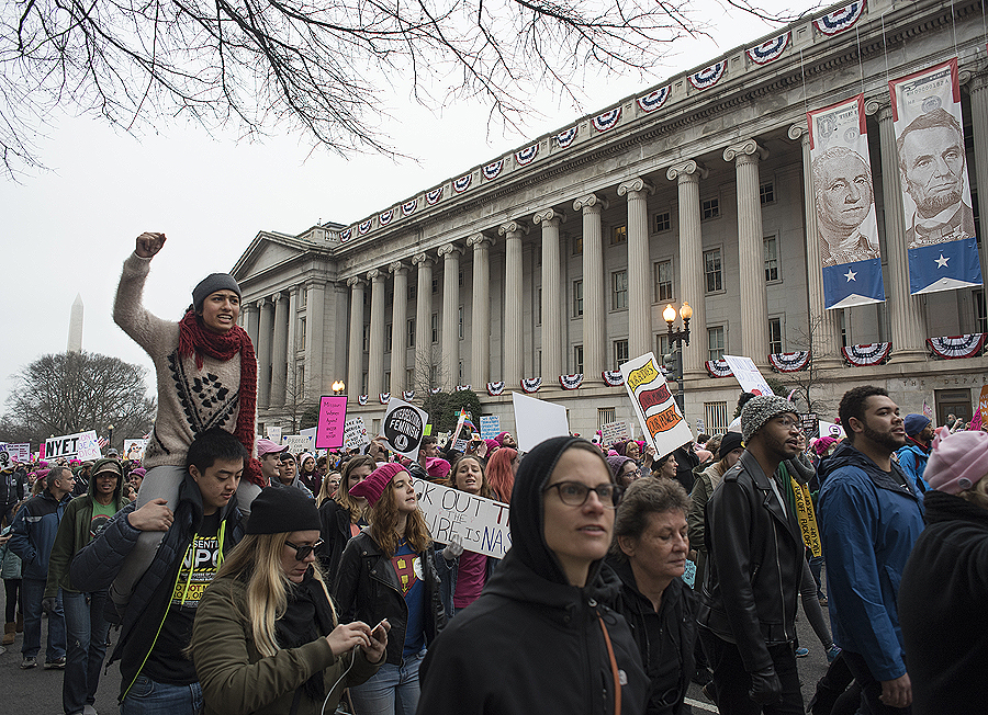 Marcher head towards The White House during Women’s March on Washington in Washington D.C. A Trump supporter uses her hands to send a message during the Women’s March on Washington in Washington D.C. (Photo by Martha Rial for PublicSource)
