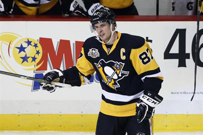 Pittsburgh Penguins' Sidney Crosby acknowledges fans as he skates back to the bench after assisting on a goal by Chris Kunitz, for the 1000th point of his NHL career, during the first period against the Winnipeg Jets in a hockey game in Pittsburgh, Thursday, Feb. 16, 2017. (AP Photo/Gene J. Puskar)