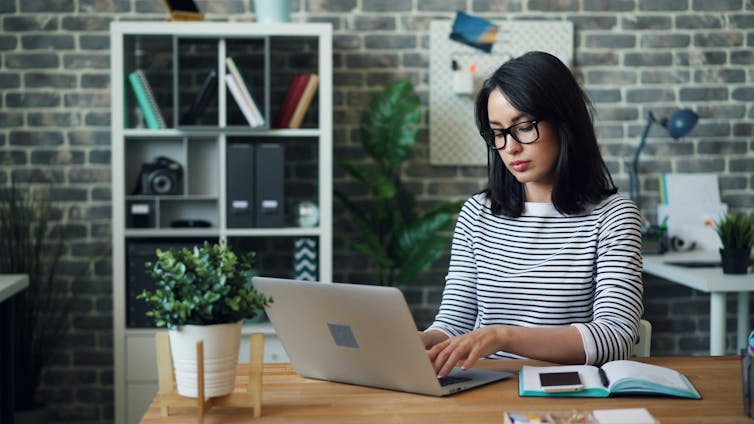 A woman sitting at a desk using a laptop