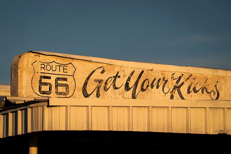 Faded sign featuring a Route 66 highway logo and the text 'Get Your Kicks.'